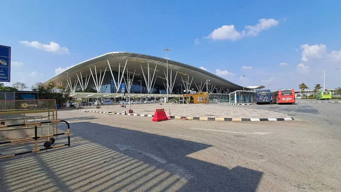 Terminal 1 building at Kempegowda International Airport, Bengaluru, with buses waiting at the kerb