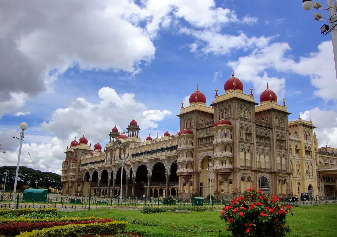 Mysore Palace (Amba Vilas Palace) in Mysuru, with red domes, arched facade and gardens