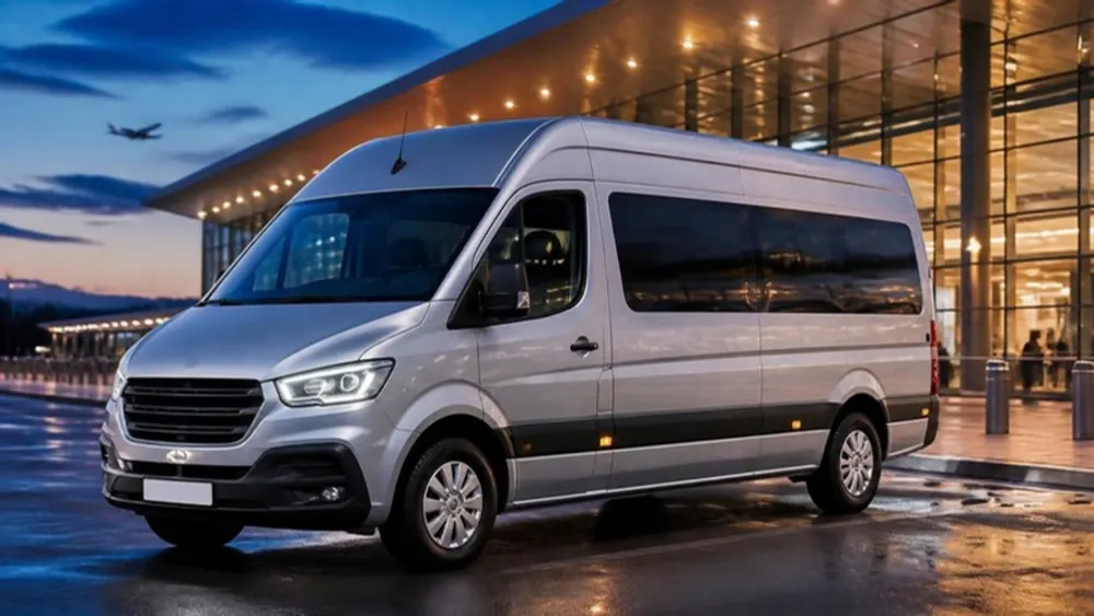 Illustration of a modern silver high-roof passenger van at an airport terminal